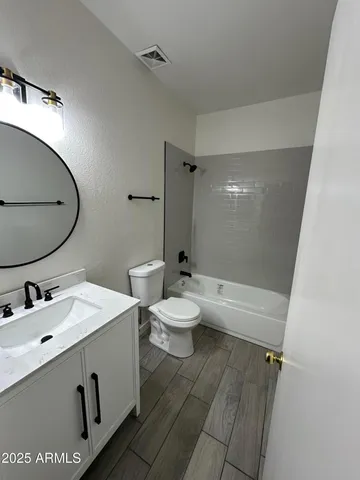 a bathroom with a sink a toilet a mirror and shower