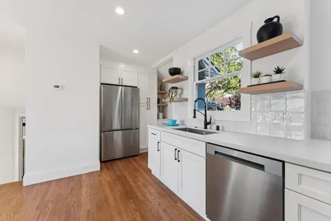 a kitchen with stainless steel appliances granite countertop a refrigerator and a sink