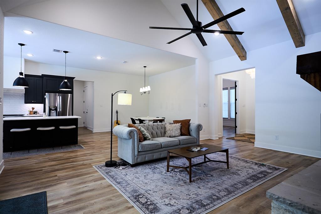 358 Glade Valley Road Azle, TX 76020 - Photo 6 of 35 Spacious living area featuring vaulted ceilings with exposed beams, wood-finish flooring, and a modern ceiling fan