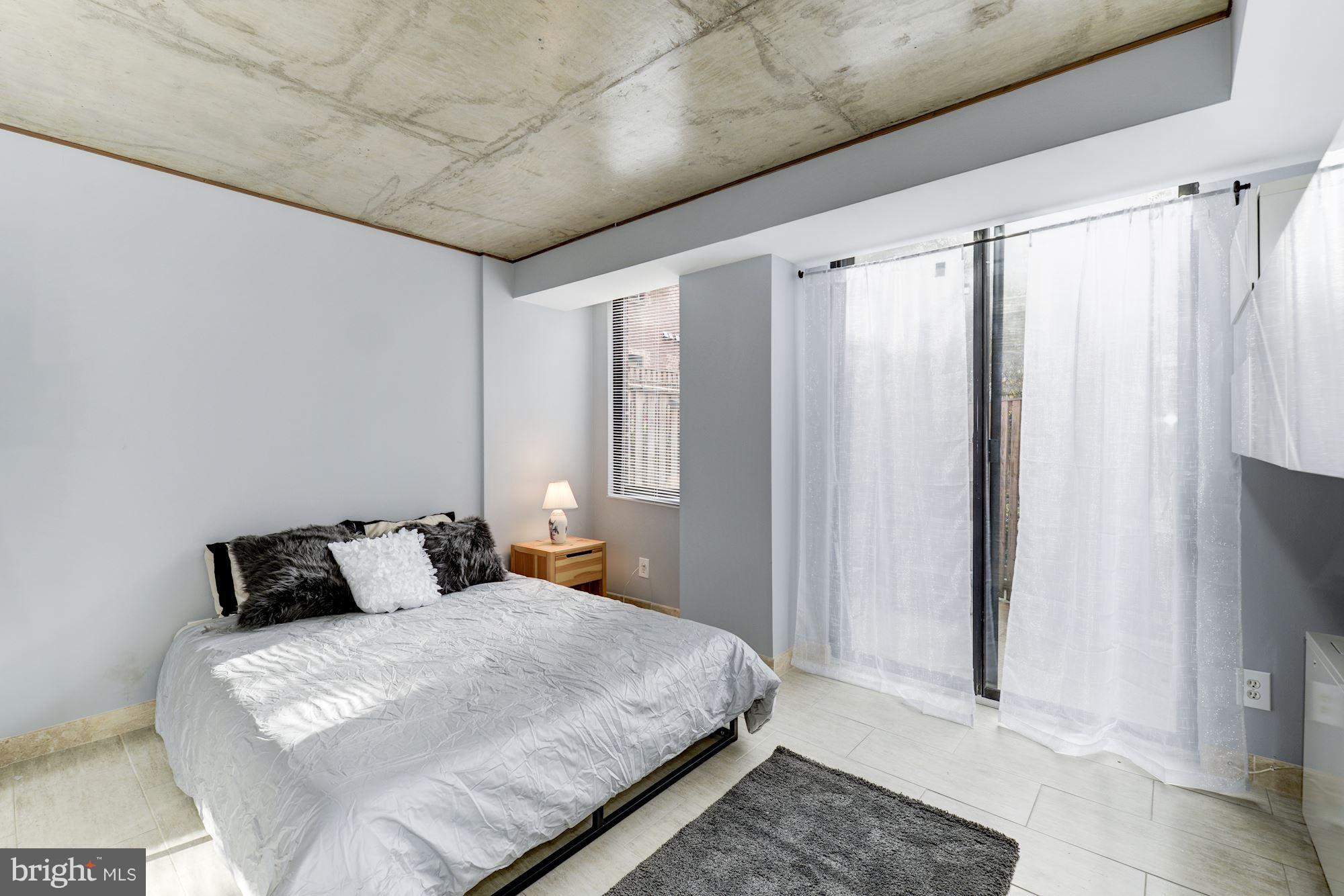 1245 13th Street Northwest, Unit 101 Washington, DC 20005 - Photo 11 of 16 a bedroom with a bed and a window