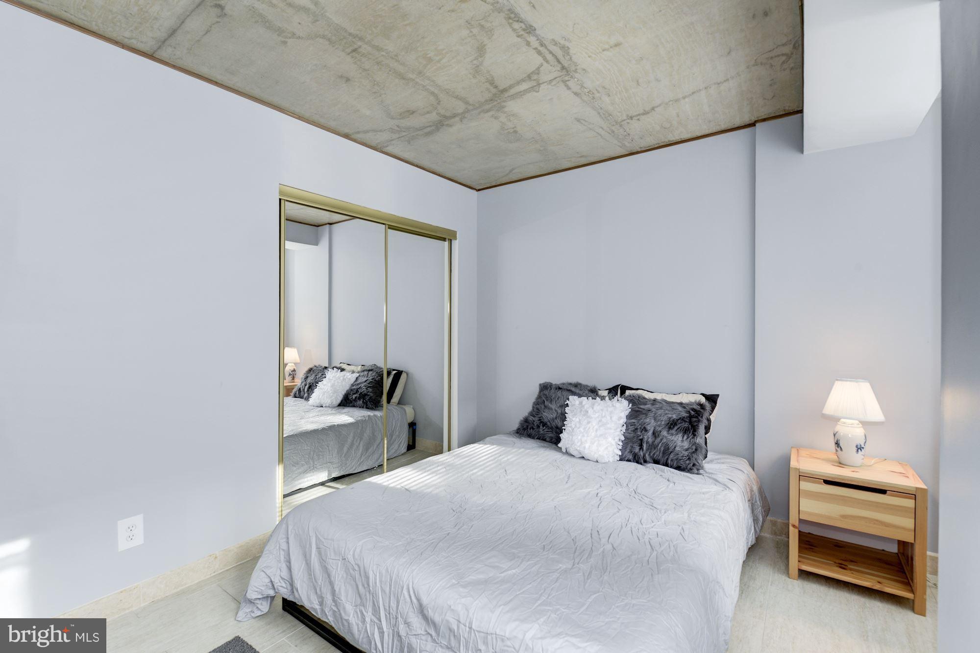 1245 13th Street Northwest, Unit 101 Washington, DC 20005 - Photo 12 of 16 a bedroom with a bed and a window