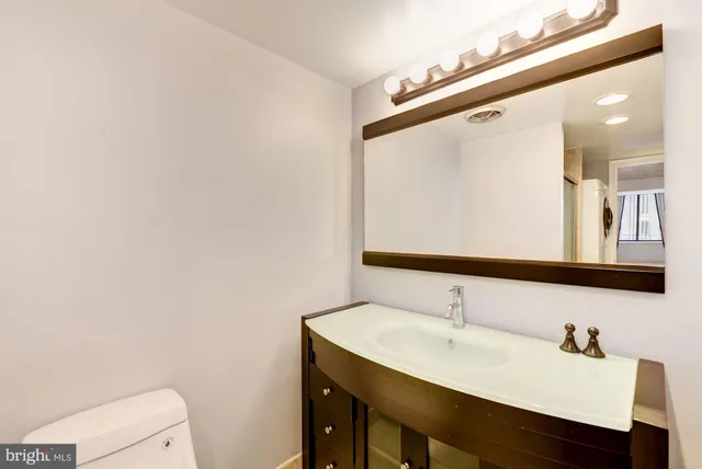 a bathroom with a sink a toilet and mirror