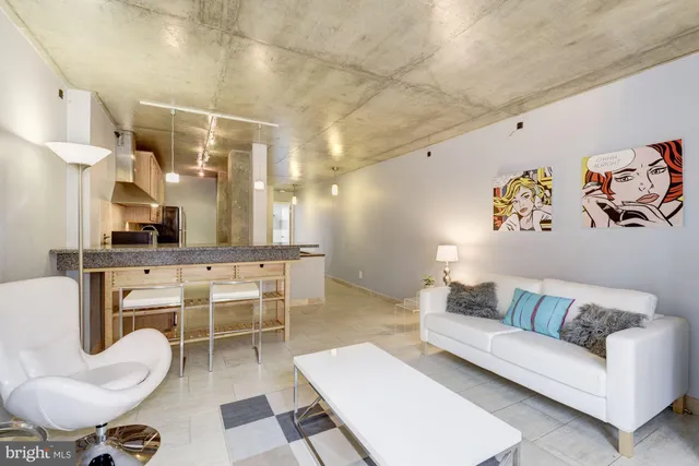 a living room with furniture a rug and white walls