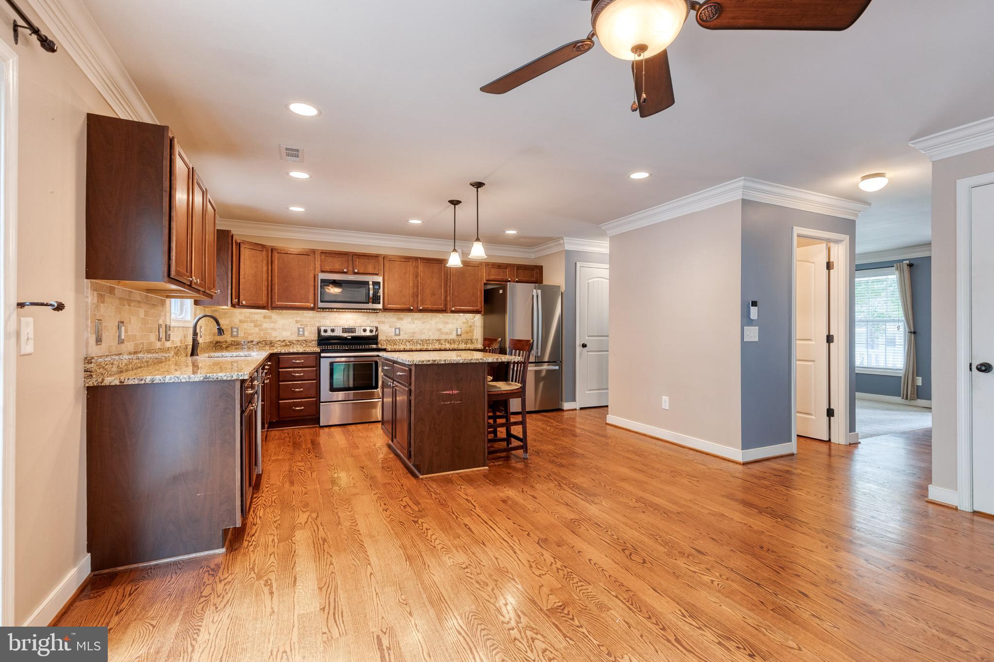 768 Stevenson Road Severn, MD 21144 - Photo 10 of 41 a kitchen with stainless steel appliances kitchen island granite countertop a refrigerator a stove top oven and a sink