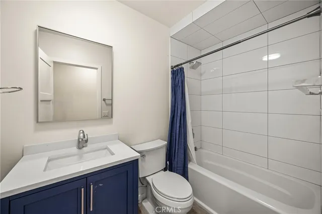 a bathroom with a granite countertop sink a toilet and shower