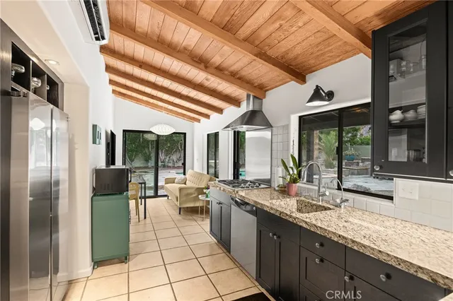 a large kitchen with stainless steel appliances granite countertop a refrigerator and a sink