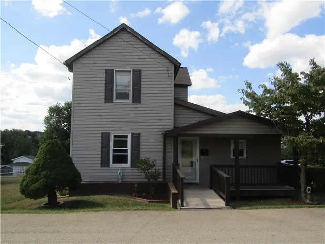 a front view of a house with a garden