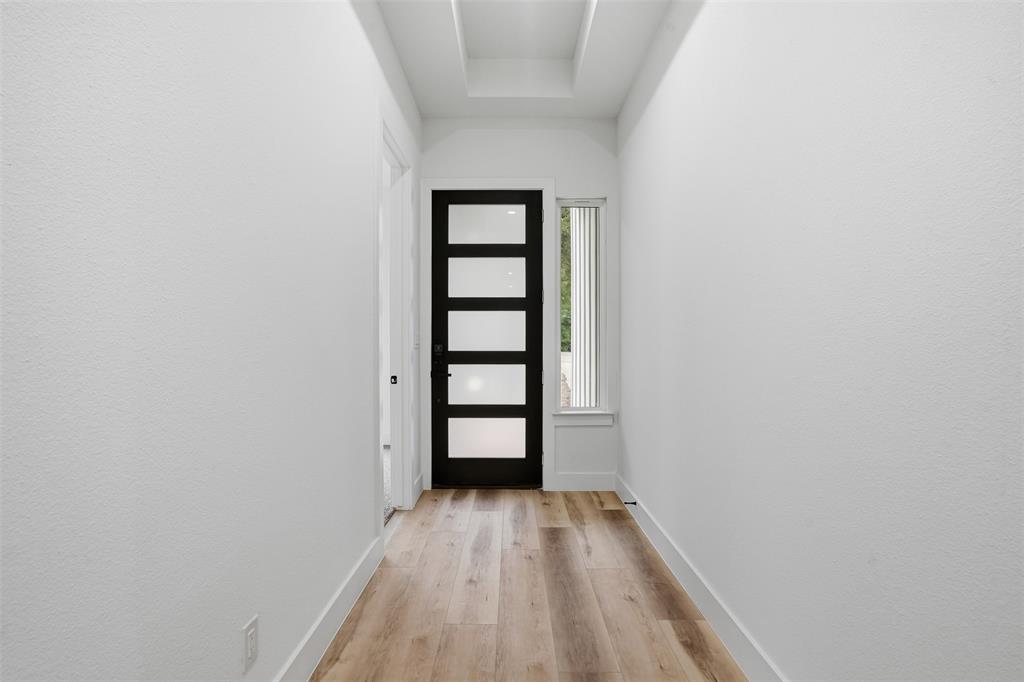 1111 Riverwood Road Dallas, TX 75217 - Photo 12 of 40 Entryway featuring a contemporary black door with five frosted glass lites, a vertical sidelight window with white blinds, and wood-finish flooring