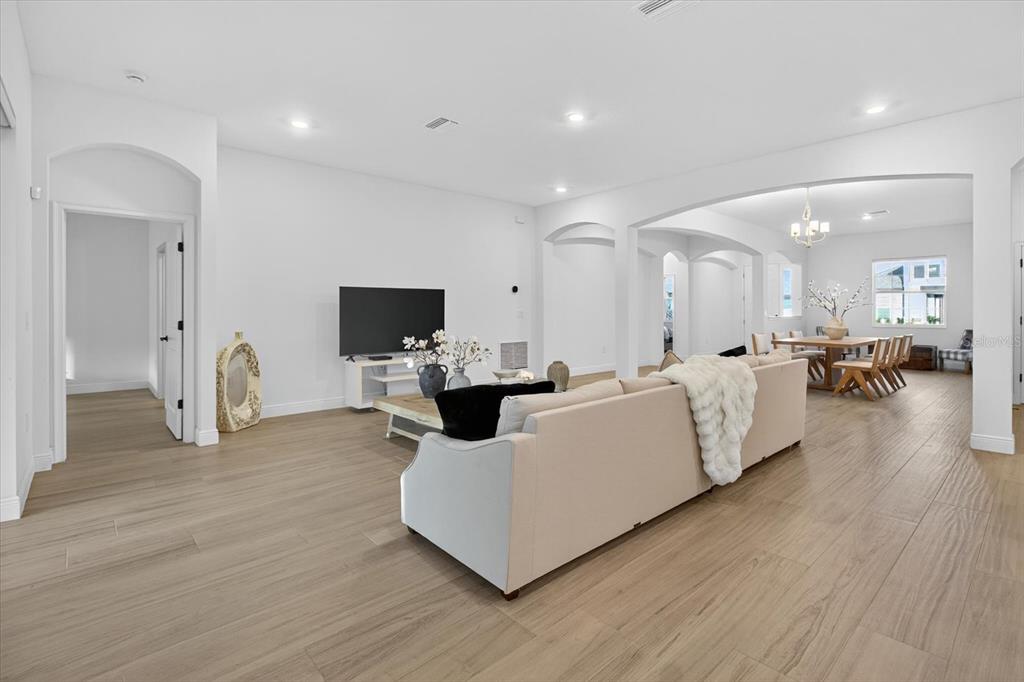 1237 Kelsa Anne Dr Spring Hill Spring Hill, FL 34609 - Photo 16 of 94 a living room with couches a flat screen tv and kitchen view