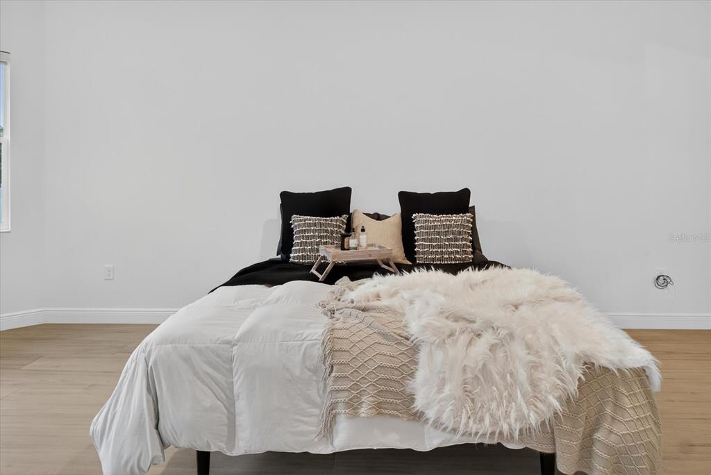 1237 Kelsa Anne Dr Spring Hill Spring Hill, FL 34609 - Photo 37 of 94 a bedroom with a bed and wooden floor