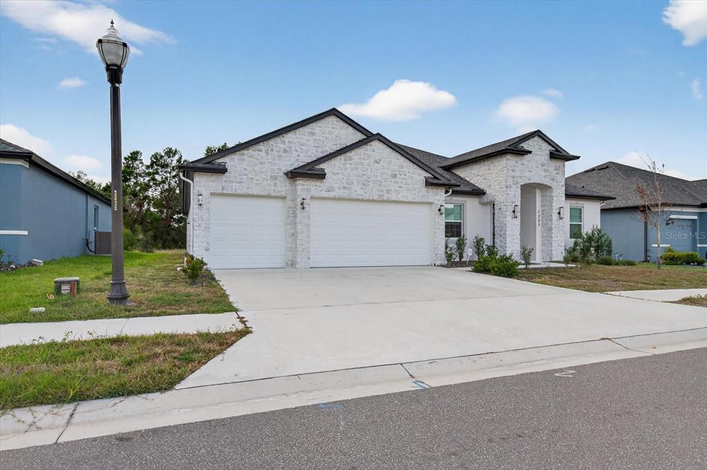1237 Kelsa Anne Dr Spring Hill Spring Hill, FL 34609 - Photo 71 of 94 a front view of a house with a garden and plants