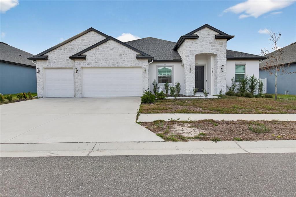 1237 Kelsa Anne Dr Spring Hill Spring Hill, FL 34609 - Photo 77 of 94 a front view of a house with a yard and garage