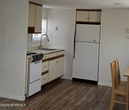 a kitchen with sink a refrigerator and wooden floor