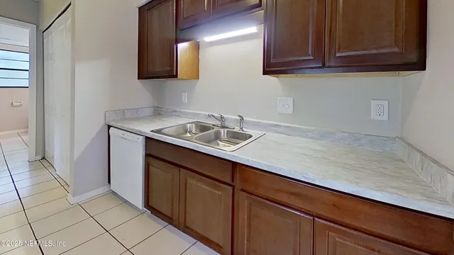 a sink with granite countertop cabinets