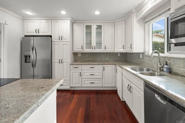 a kitchen with granite countertop white cabinets and white appliances