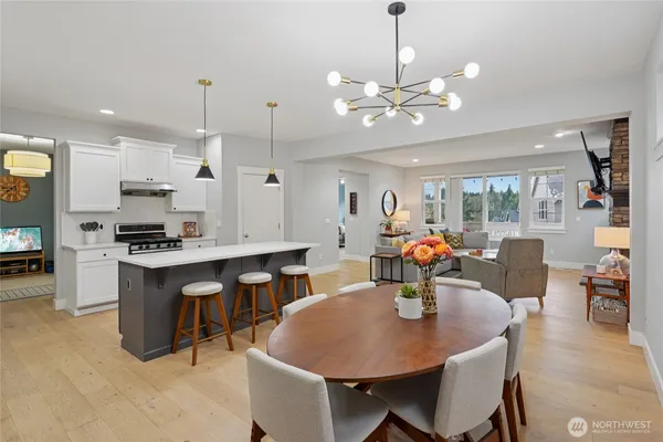 a kitchen with stainless steel appliances kitchen island granite countertop a table chairs and a refrigerator