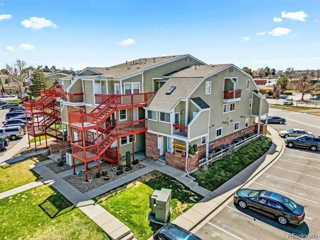 an aerial view of a house with swimming pool and large trees