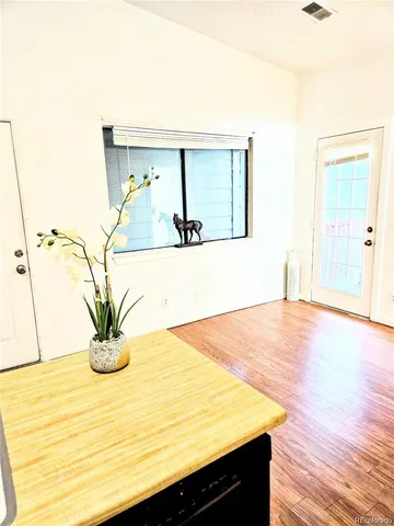 a view of a room with wooden floor and a potted plant