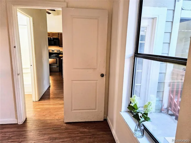 a view of a hallway with wooden floor and a potted plant
