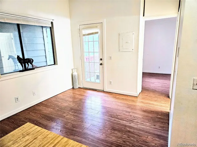 a view of a hallway with wooden floor and closet