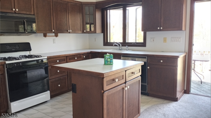 83 Lakeside Drive Vernon, NJ 07461 - Photo 17 of 34 a kitchen with a stove sink and cabinets