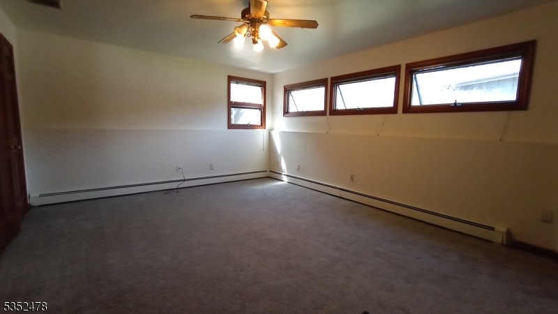 83 Lakeside Drive Vernon, NJ 07461 - Photo 8 of 34 an empty room with windows and chandelier fan