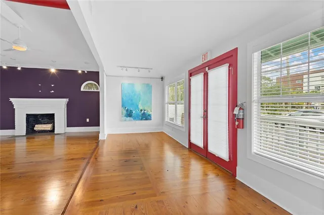 an empty room with windows and fireplace