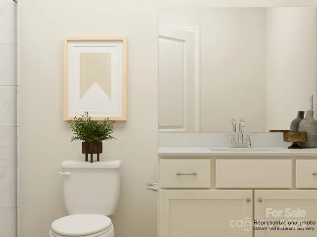 a bedroom with a bed and a lamp on dresser