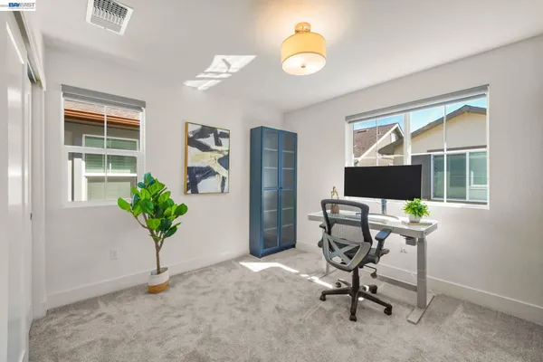 a view of a workspace with furniture and a window