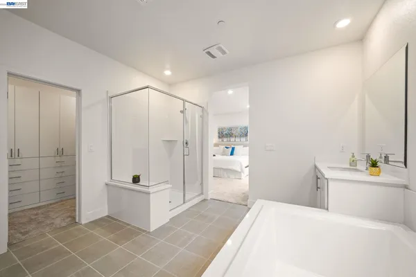 a bathroom with a tub shower a sink and mirror