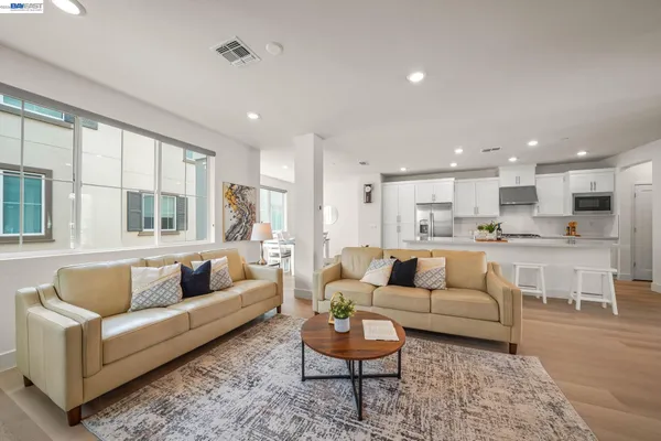 a living room with furniture white walls and a view of kitchen