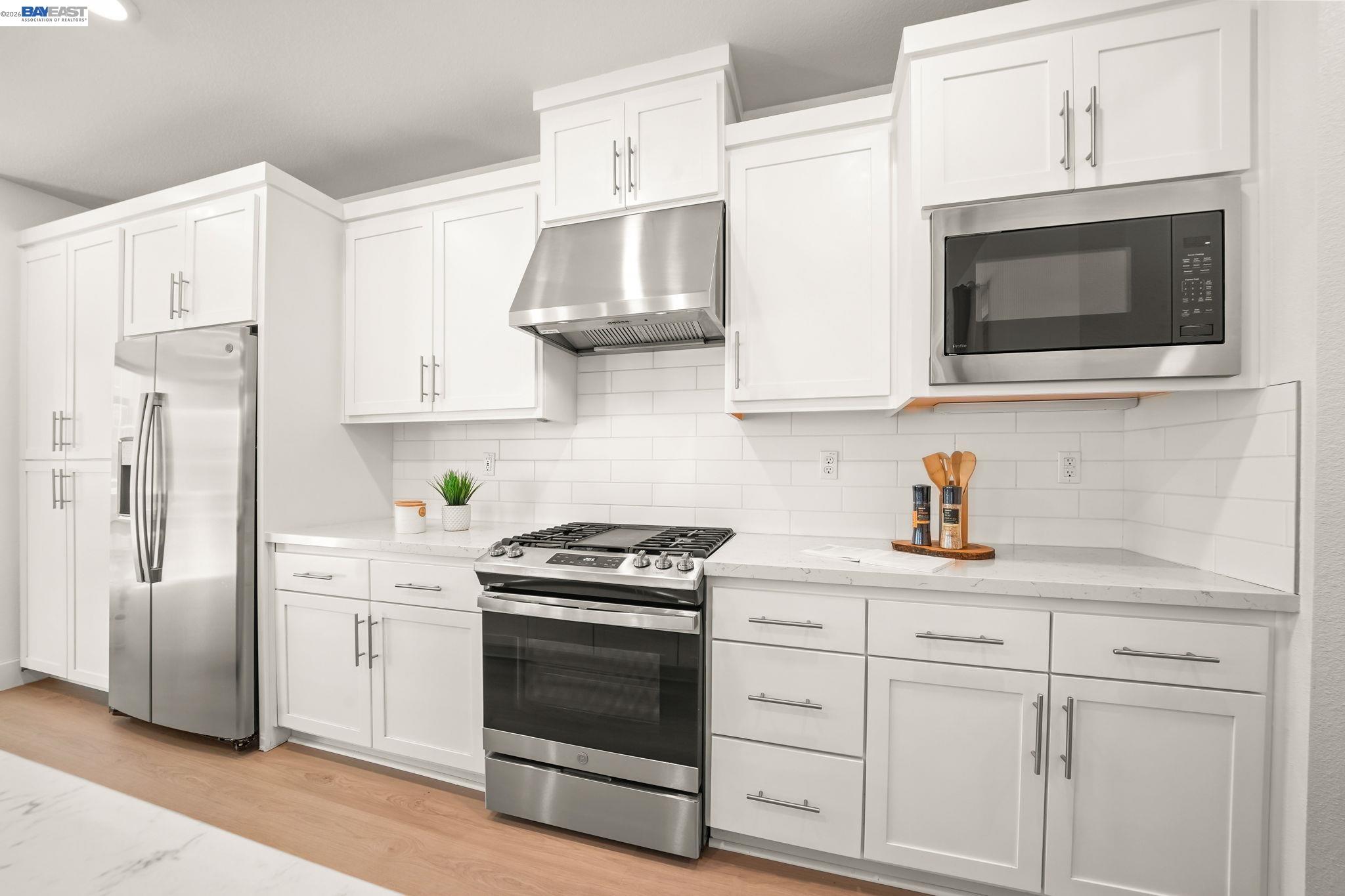 9034 Rudder Way Newark, CA 94560 - Photo 9 of 42 a kitchen with stainless steel appliances granite countertop white cabinets a stove a sink and dishwasher