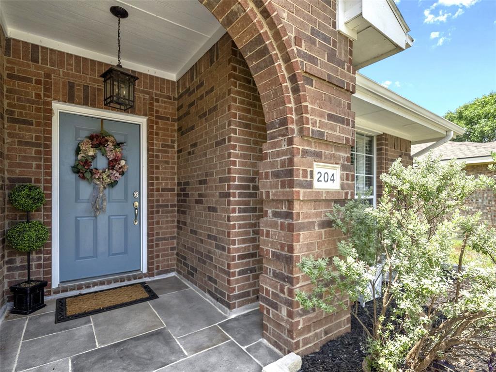 204 Arbor Ridge Drive Allen, TX 75002 - Photo 4 of 36 Brick facade with an arched entry and stone tile porch