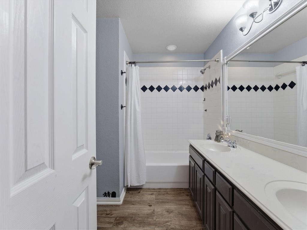 10000 Fireside Lane Forney, TX 75126 - Photo 14 of 40 Full bath with double vanity, dark wood-style flooring, and shower / tub combo