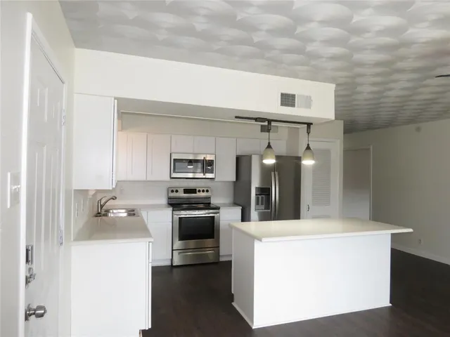 a kitchen with stainless steel appliances a sink and stove top oven