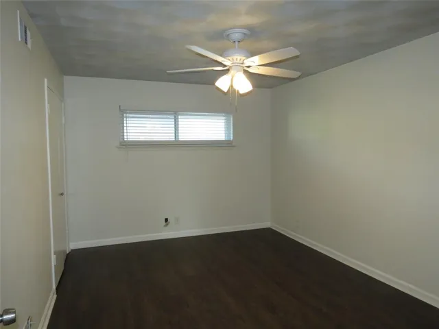 a view of a room that has a fan and window