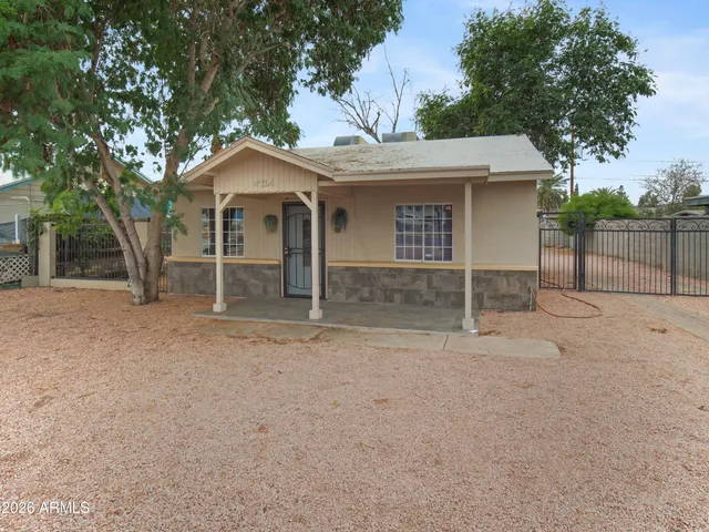 front view of a house with a yard and a large tree