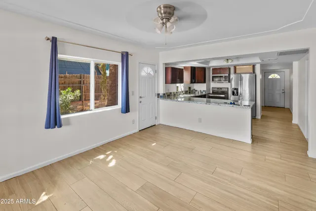 a view of a livingroom with a kitchen and microwave