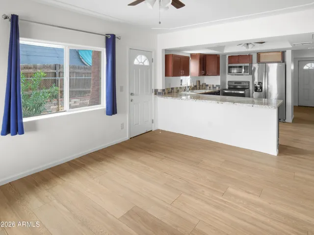 an empty room with windows and fan