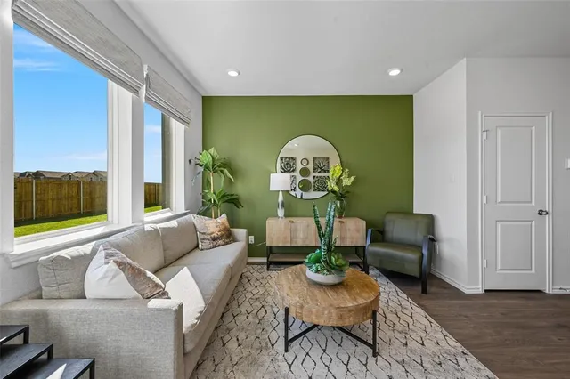 a living room with furniture a rug and a window