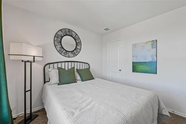 a bedroom with a bed and a lamp