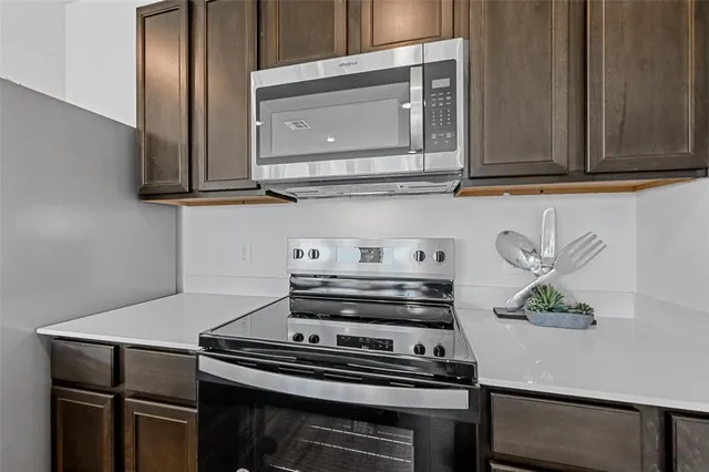 a kitchen with a sink a stove and chairs with wooden floor
