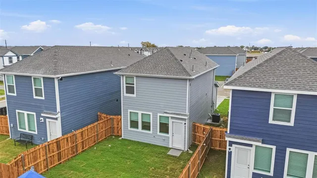 a living room with stainless steel appliances furniture wooden floor and a kitchen view