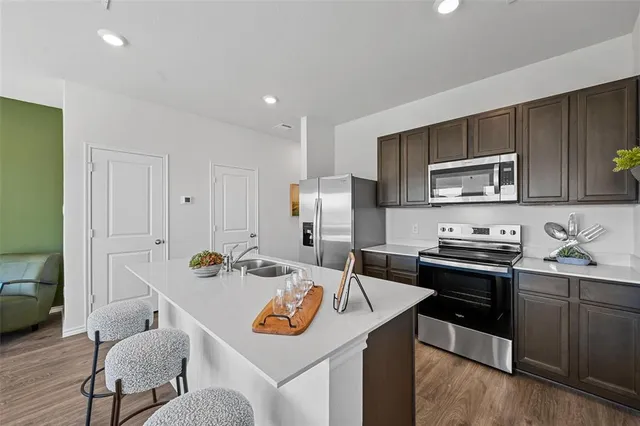 a kitchen with a refrigerator a stove a microwave a sink and cabinets