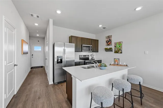 a kitchen that has a sink and a stove top oven