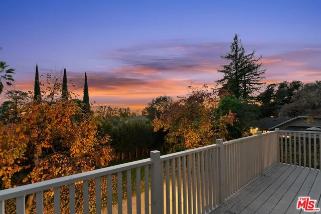 a balcony with wooden floor and city view