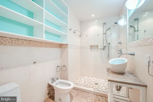 a bathroom with a sink toilet a mirror and shower