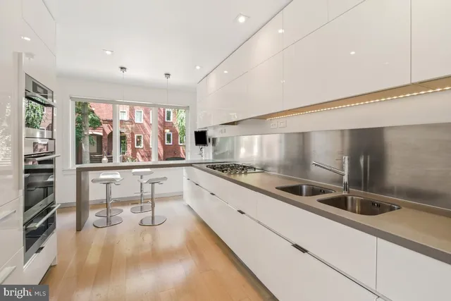 a kitchen with stainless steel appliances kitchen island granite countertop a stove and a sink