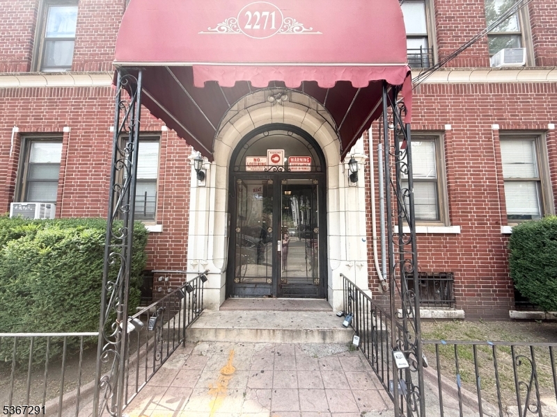 a view of a brick house with large windows and a pathway