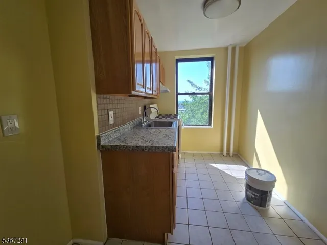 a bathroom with a granite countertop sink a mirror and a bathtub